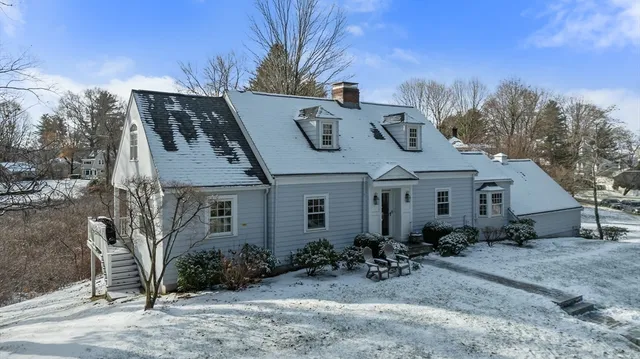 a view of a house with potted plants and large trees