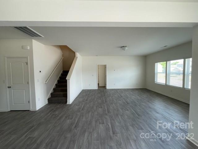 809 Alexander Commons Drive, Unit 34 Monroe, NC 28112 - Photo 6 of 28 a view of an empty room with wooden floor and a window