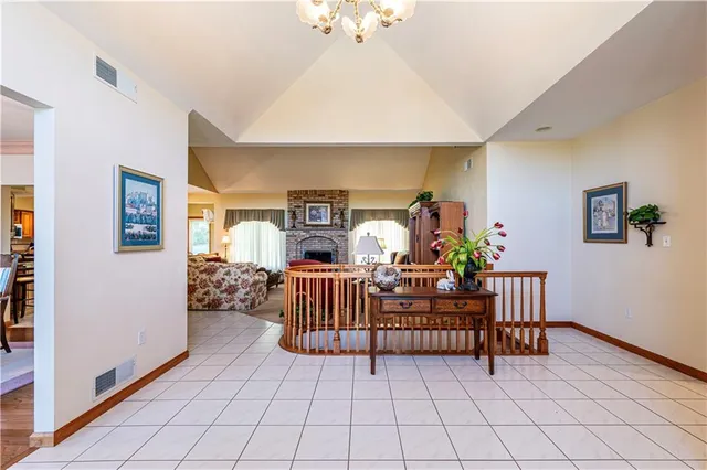 a living room with furniture a chandelier and a flat screen tv