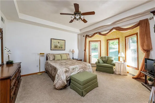 a bedroom with a bed a couch and a chandelier