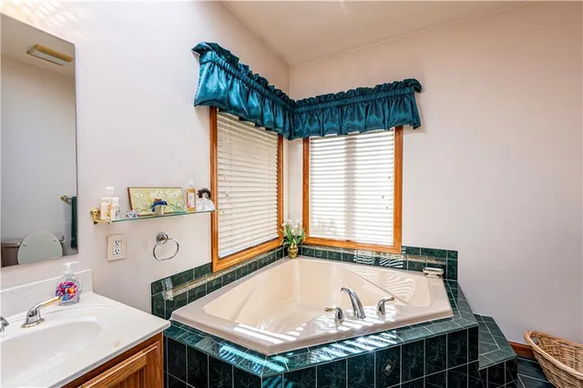 a bathroom with a tub sink and a window