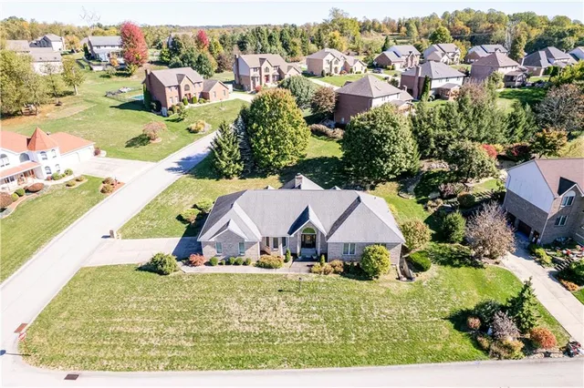 an aerial view of residential houses with outdoor space and trees