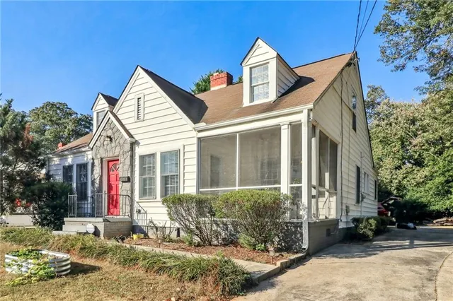 a view of a white house with a yard and large tree