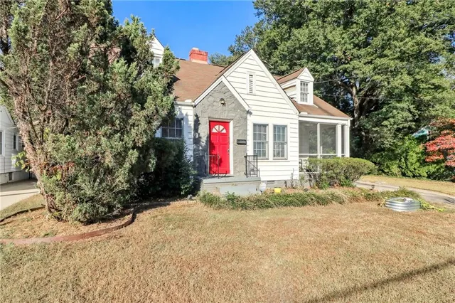 a view of a white house with a yard and large tree