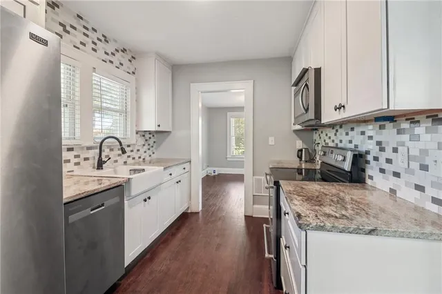 a kitchen with sink stove and cabinets