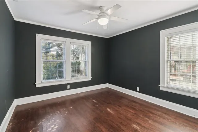 a view of an empty room with a window and a kitchen