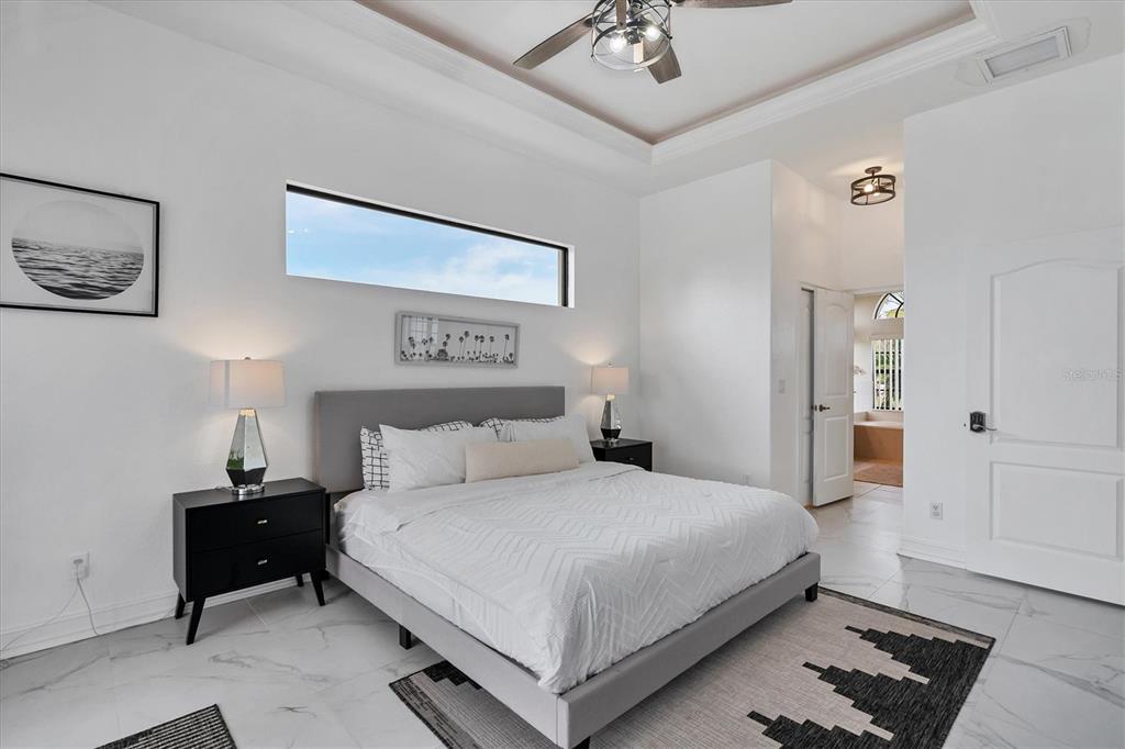 24017 Peppercorn Road Punta Gorda, FL 33955 - Photo 16 of 38 a bedroom with a bed and a chandelier