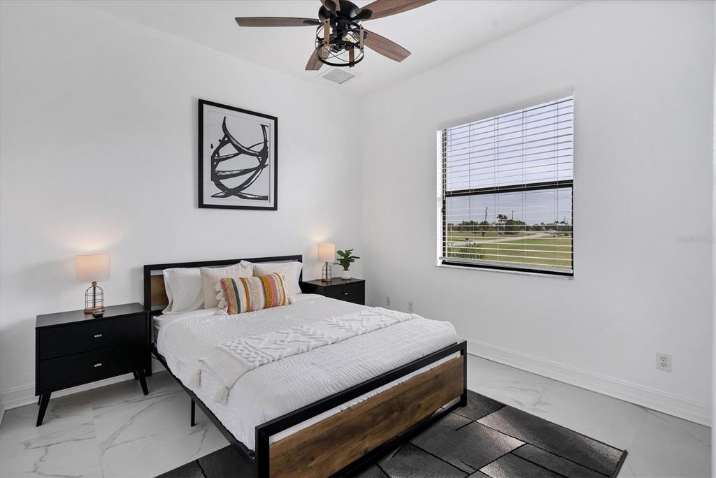 24017 Peppercorn Road Punta Gorda, FL 33955 - Photo 20 of 38 a bedroom with a bed and a chandelier