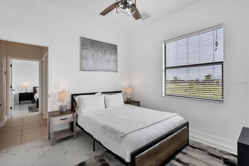 24017 Peppercorn Road Punta Gorda, FL 33955 - Photo 22 of 38 a bedroom with a bed and a chandelier