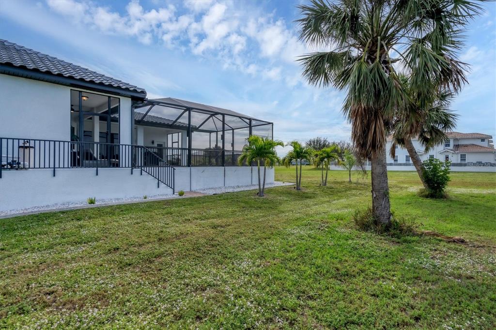 24017 Peppercorn Road Punta Gorda, FL 33955 - Photo 36 of 38 a backyard of a house with lots of green space and fountain