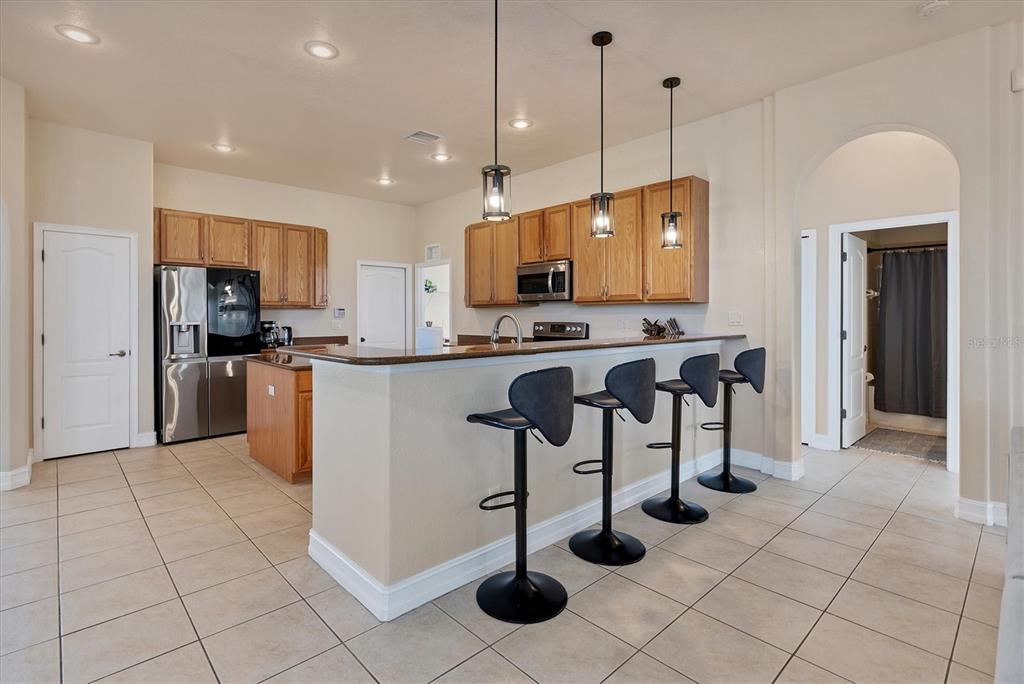 24017 Peppercorn Road Punta Gorda, FL 33955 - Photo 7 of 38 a kitchen with stainless steel appliances granite countertop a stove a sink a refrigerator and a wooden cabinets