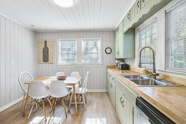 a kitchen with a table chairs sink and cabinets