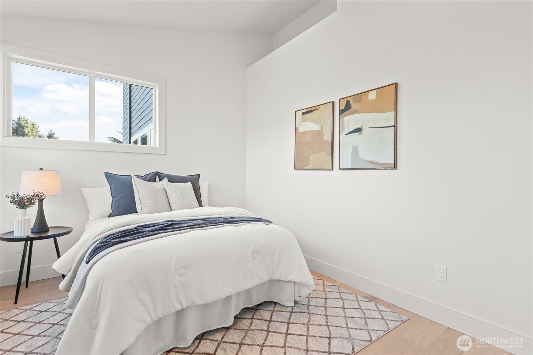 7350 22nd Avenue Northwest, Unit B Seattle, WA 98117 - Photo 13 of 24 a bed sitting in a bedroom next to a window