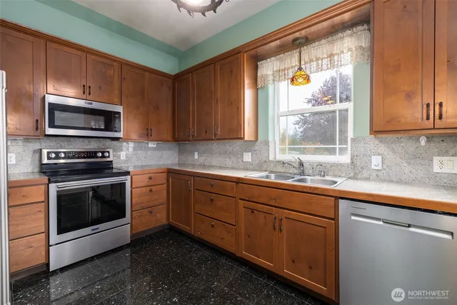 a kitchen with sink a microwave and cabinets