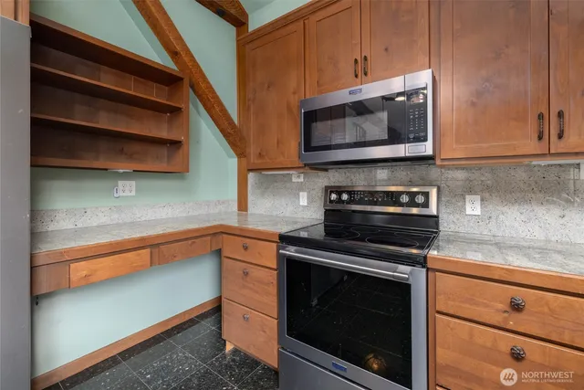 a kitchen with stainless steel appliances granite countertop a stove microwave and cabinets