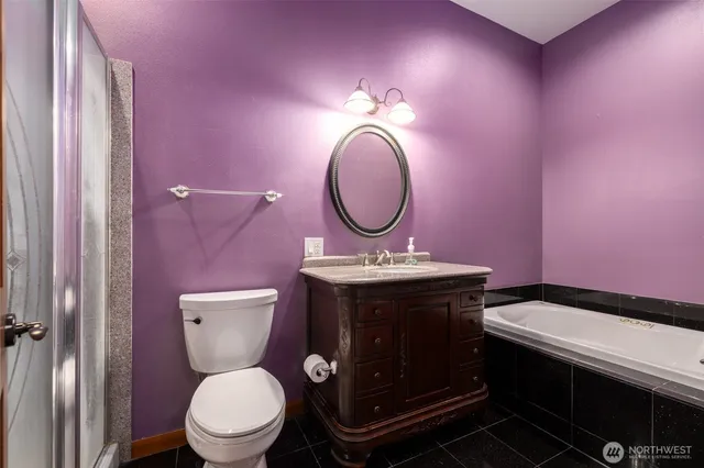 a bathroom with a toilet sink vanity and mirror