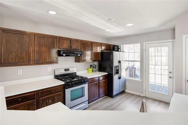 a kitchen with stainless steel appliances granite countertop a sink stove and refrigerator