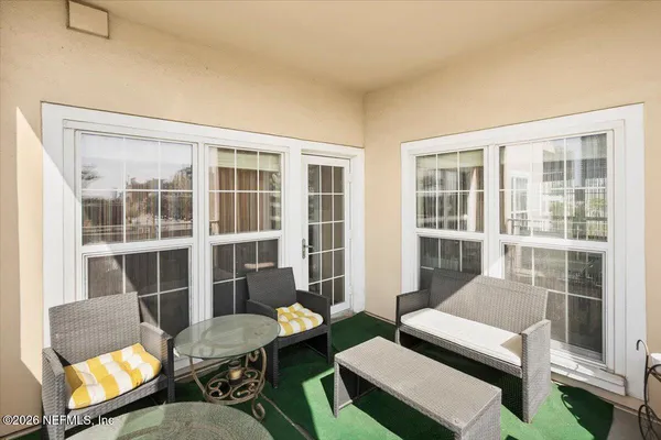 a living room with furniture a rug and a floor to ceiling window