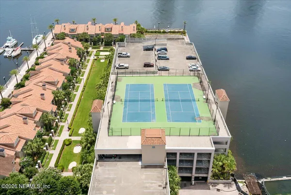 a front view of a house with a garden and lake view