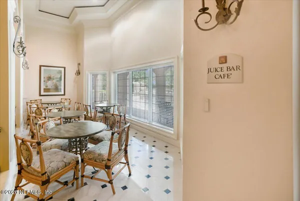 a dining room with wooden floor a chandelier a glass table and chairs