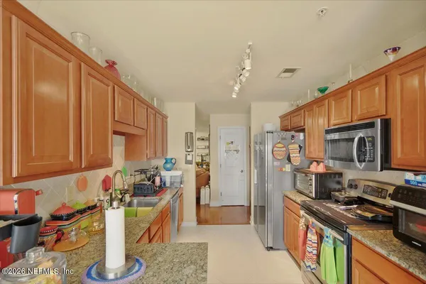 a kitchen with stainless steel appliances granite countertop a refrigerator stove and sink