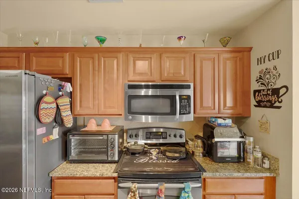 a kitchen with granite countertop a stove and a refrigerator