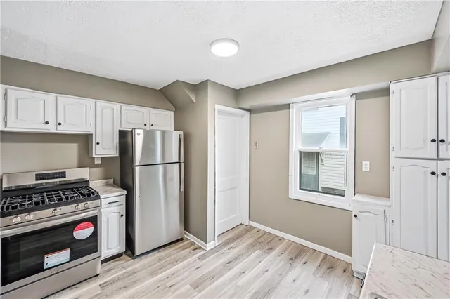 a view of empty room with wooden floor and ceiling fan