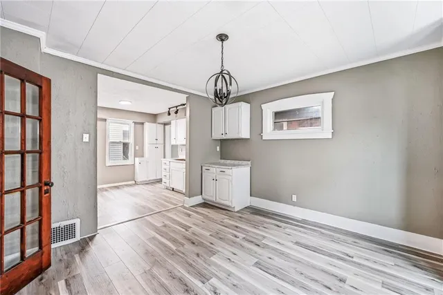 a view of empty room with wooden floor and window