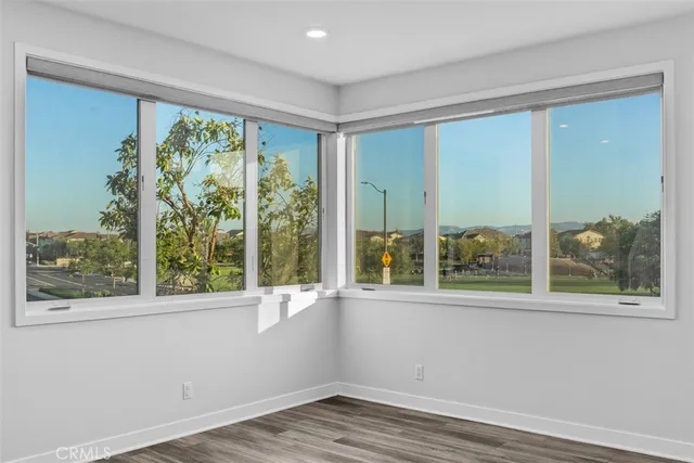 a view of a room with a large window and wooden floor