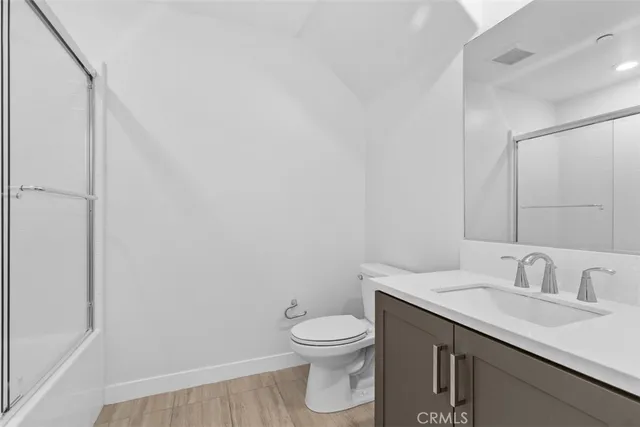 a bathroom with a granite countertop sink a toilet and a mirror