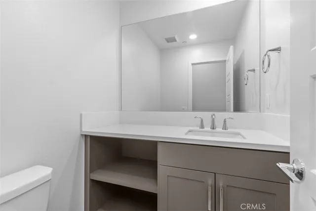 a bathroom with a sink a toilet a mirror and vanity