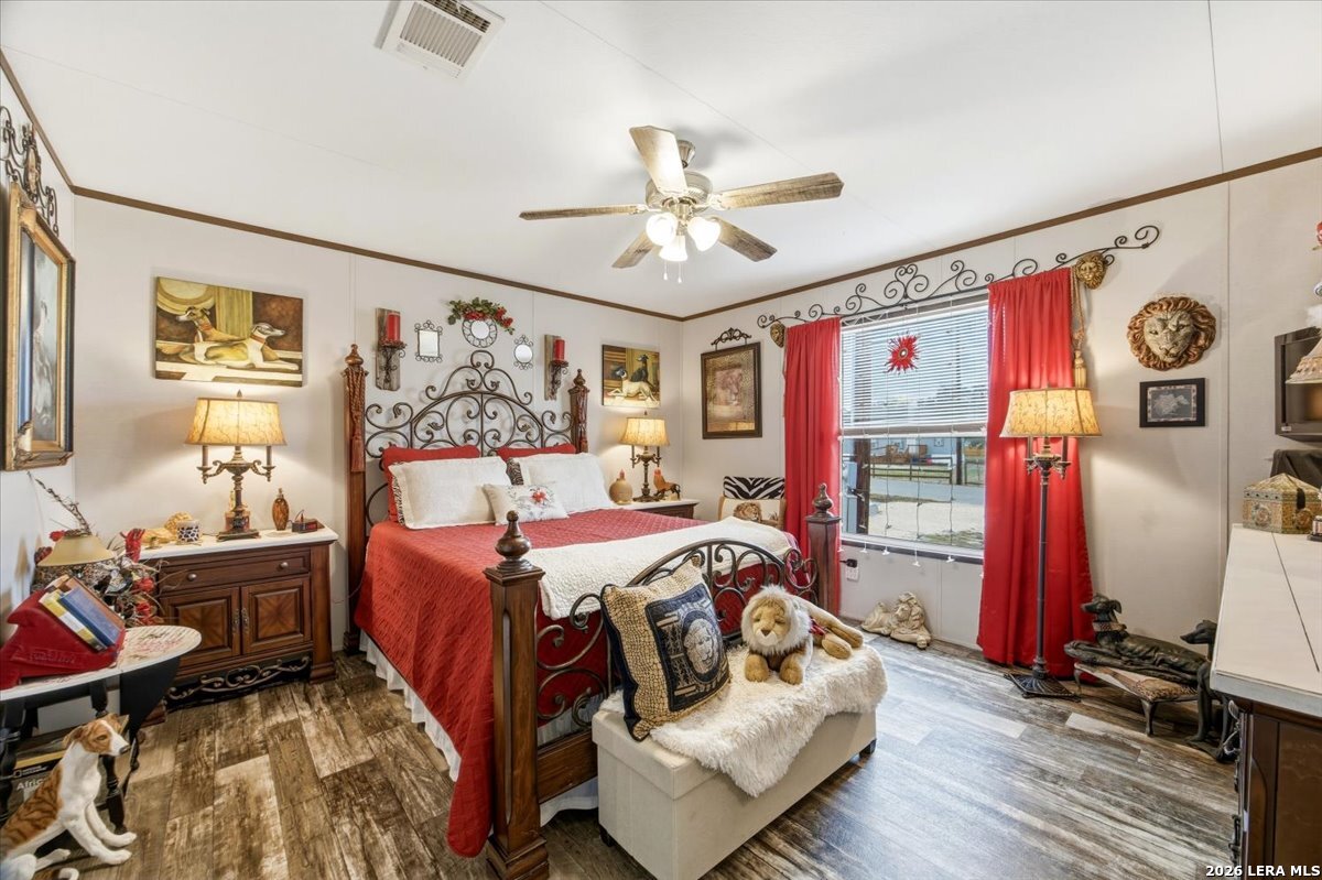 101 Rocky Ridge Drive Poteet, TX 78065 - Photo 18 of 36 a bedroom with furniture and a wooden floor