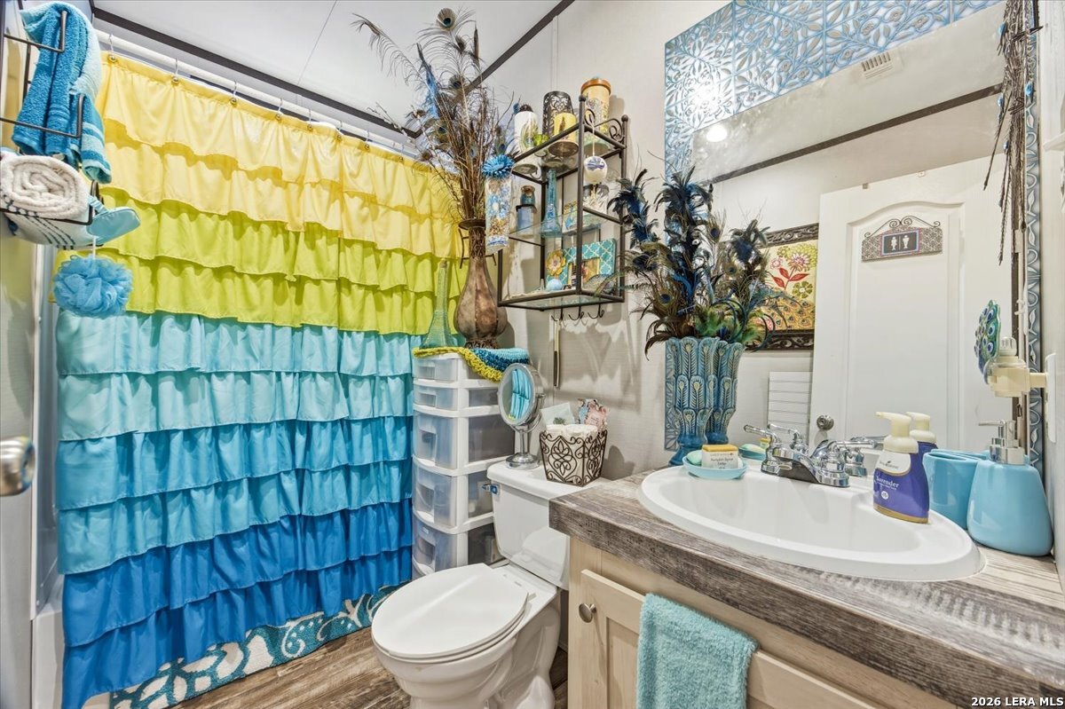 101 Rocky Ridge Drive Poteet, TX 78065 - Photo 25 of 36 a bathroom with a sink a toilet and shower curtain
