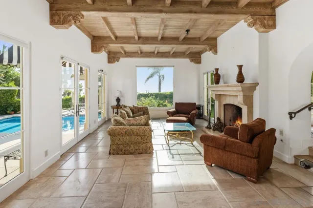 a living room with furniture a fireplace and a chandelier