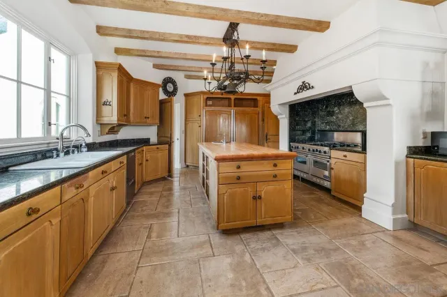 a large kitchen with stainless steel appliances kitchen island granite countertop a sink and cabinets