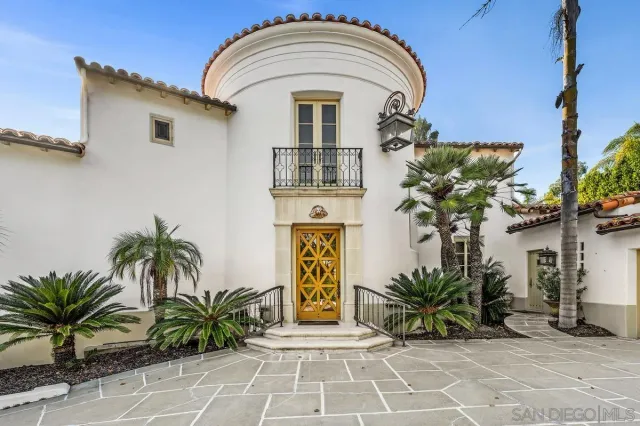 a front view of a house with a glass door and potted plants