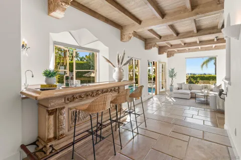 a dining hall with stainless steel appliances kitchen island granite countertop a table and chairs