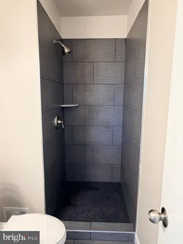 a bathroom with a toilet and a shower