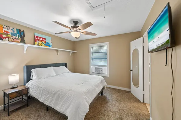 a bedroom with a bed a ceiling fan and a book shelf