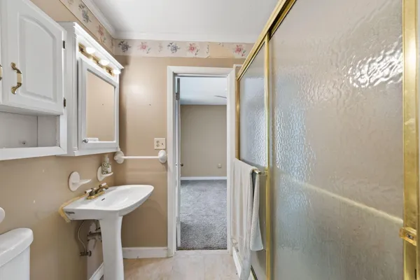 a bathroom with a sink a toilet and shower