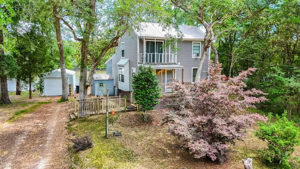 a view of a house with a yard and large trees