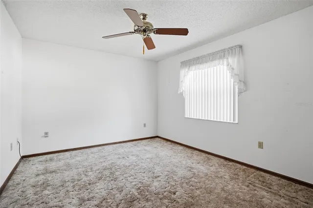 a view of empty room with ceiling fan