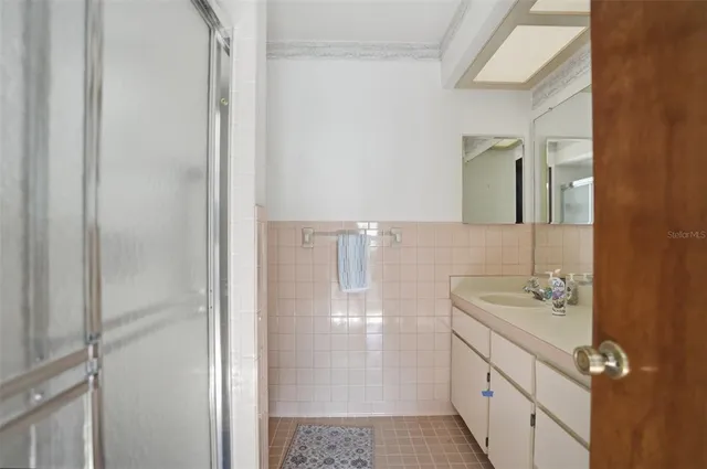 a bathroom with a sink a mirror and shower