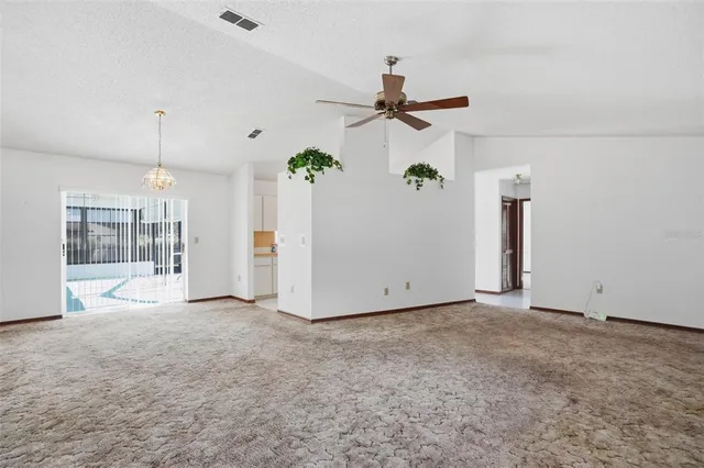 a view of a room with a refrigerator and ceiling fan