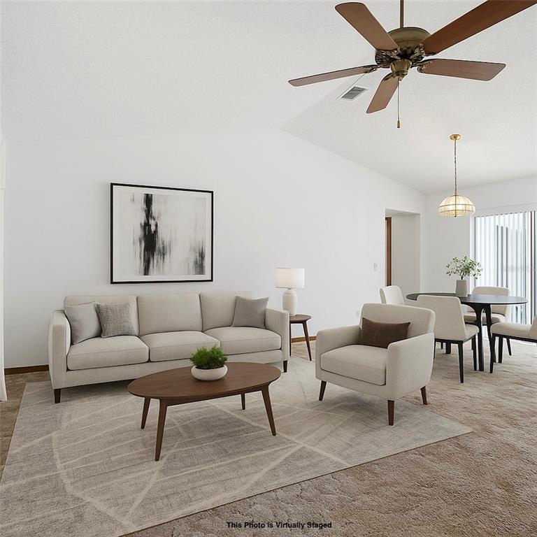 2414 Appian Avenue Spring Hill, FL 34608 - Photo 6 of 37 a living room with furniture a rug and a chandelier