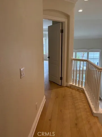 a view of an empty room with window and chandelier fan