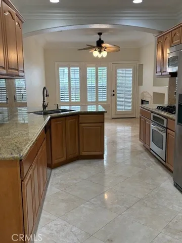 a large kitchen with granite countertop a sink and dishwasher a stove top oven with wooden floor