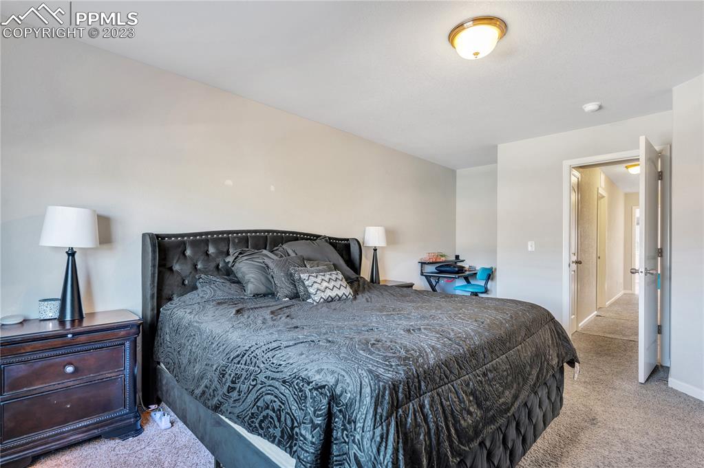 2118 Birmingham Loop Colorado Springs, CO 80910 - Photo 14 of 28 a bedroom with a bed and a lamp