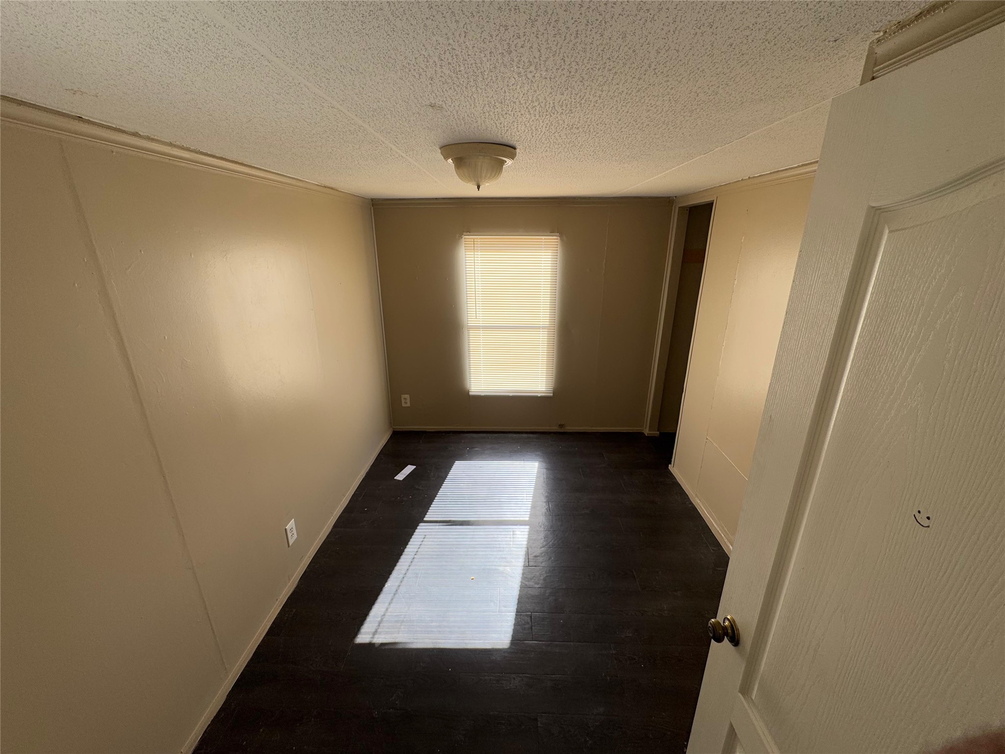 8315 Burleson Manor Road, Unit B Manor, TX 78653 - Photo 6 of 15 Spare room featuring dark wood-style floors and a textured ceiling