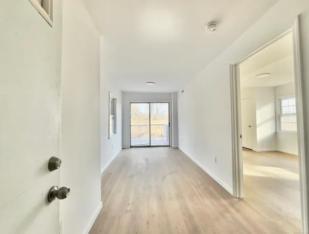 a view of hallway with a bathroom